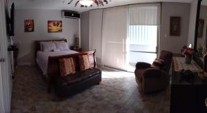 1 dormitorio con 1 cama, 1 sofá y 1 silla en Saint Tropez, en San Juan