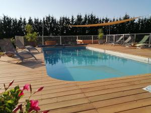 una piscina en una terraza de madera con una terraza de madera en Maison avec vue Pyrénées et piscine chauffée, en Aignes
