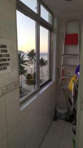 a bathroom with a window with a view of the beach at Apartamento em Praia Grande in Praia Grande