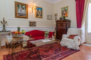 sala de estar con sofá rojo y mesa en La casa di Dante en Palermo