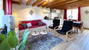 a living room with a red couch and chairs at La Capelette in Escalles