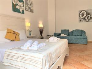 a bedroom with a bed with towels on it at Badia Rooms & Breakfast in Castellammare del Golfo