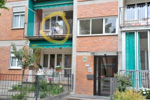 ceglany budynek z balkonem i drzwiami w obiekcie Casa Serena w mieście Ivrea