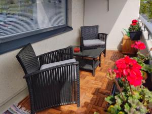 un patio con 2 sillas, una mesa y flores en Niinivaara apartment saunallinen ja ilmastoitu majoitus en Joensuu