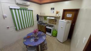 a small kitchen with a table and a refrigerator at APART HOTEL MANAUS - Un 614 in Manaus