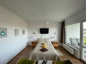a bedroom with a bed and a tv on the wall at Studió Apartmanok in Balatonfüred