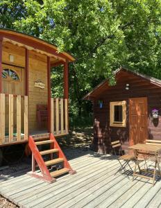 une cabine avec une terrasse en bois et une table dans l'établissement Kerca Bio Farm, à Kercaszomor