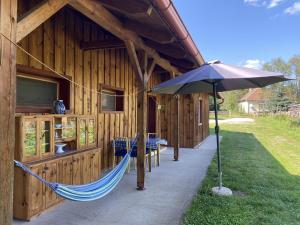 a hammock in front of a building with an umbrella at Kerca Bio Farm in Kercaszomor