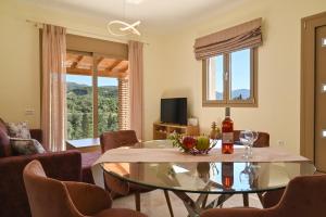 a living room with a glass table and chairs at Villa Ioanna in Liapades