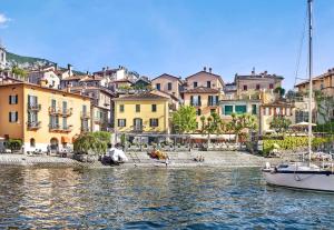 uma vista da cidade a partir da água com um barco em Casa Giada em Varenna