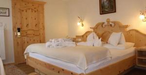 a bedroom with a large bed with white sheets at Hotel Edelweiẞ garni in Berwang