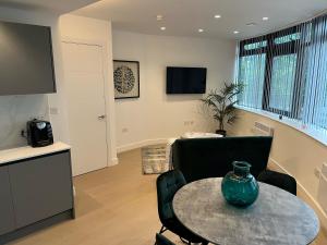 a living room with a table with a vase on it at Brentford Apartments by Charles Hope in Brentford