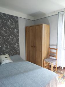 een slaapkamer met een bed, een stoel en een muur bij Appartement 1er étage banyuls sur mer départs et arrivées les samedis in Banyuls-sur-Mer