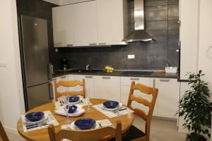 Il dispose d'une cuisine avec une table en bois et des plats bleus. dans l'établissement Apartment D&E Punat - free parking and Wi-Fi, à Punat