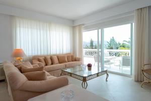 a living room with a couch and a table at Kamariyo Athens Riviera by A&D Properties in Palaia Fokaia