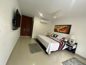 a bedroom with a bed and a flat screen tv at Girardot Casa con Piscina Privada Campestre in Flandes