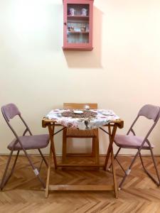 two chairs and a table with a table cloth on it at KRAGUJ apartments 1 in Kragujevac