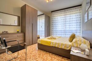 1 dormitorio con cama, tocador y espejo en CaseOspitali - CASA LUCE a due passi dal SAN RAFFAELE - 1 bedroom e divano in soggiorno, en Vimodrone