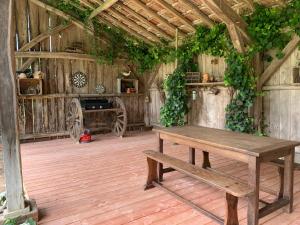 um celeiro de madeira com uma mesa e uma lareira em Les Ailes du Temps em Caupenne-dʼArmagnac