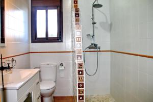a bathroom with a shower and a toilet and a sink at Apartamento Playa Bolonia in Bolonia +14 photos