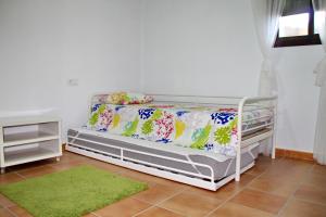 a bedroom with a white bed and a green rug at Apartamento Playa Bolonia in Bolonia