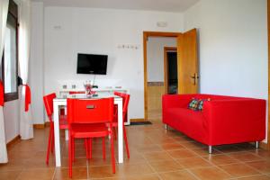 a living room with a red couch and a table and chairs at Apartamento Playa Bolonia in Bolonia