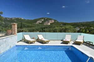 a swimming pool with two lounge chairs next to a swimming pool at Villa Ioanna in Liapades