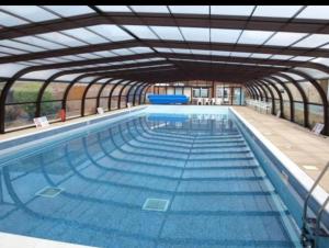 a large swimming pool with a large glass ceiling at 18, Waterside park, Fernly Holiday Home in Corton