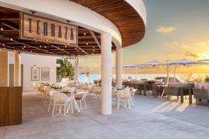a restaurant on the beach with tables and chairs at Le Blanc Spa Resort Cancun Adults Only All-Inclusive in Cancún