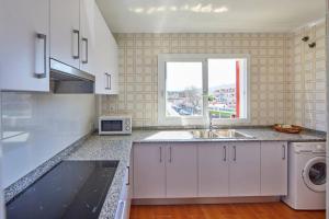 a white kitchen with a sink and a window at Nura Houses Duplex Magaluf 4 in Magaluf