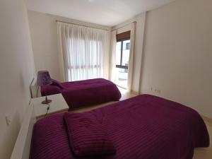 Amplio apartamento en Portofino Alcaidesa tesisinde bir odada yatak veya yataklar