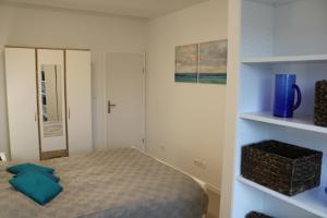 a small bedroom with a bed and a cabinet at Apartment D&E Punat - free Wi-Fi and parking in Punat