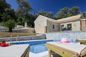 een villa met een zwembad en een huis bij Villa Ioanna in Liapades