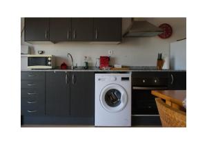 een keuken met een wasmachine en een magnetron bij Lo Mirador del Passador in Sant Jaume d'Enveja