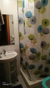 baño con lavabo y cortina de ducha con sombrillas en Apartamentos Punta Canaret Altamar, en Alcossebre