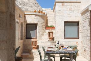 een patio met een tafel met eten en drinken erop bij TRULLI CALELLA by Apulia Hospitality in Locorotondo
