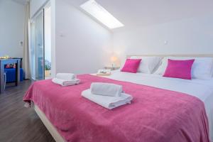 two large white beds with pink and white towels on them at Villa Fio - Rooms & Studio in Hvar