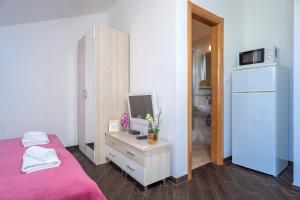 a bedroom with a bed and a computer on a desk at Villa Fio - Rooms & Studio in Hvar