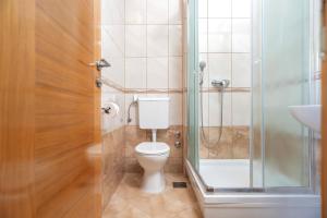 a bathroom with a toilet and a glass shower at Villa Fio - Rooms & Studio in Hvar