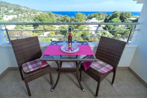 a table with a drink and two chairs on a balcony at Villa Fio - Rooms & Studio in Hvar
