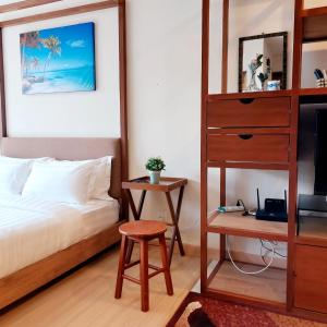 a bedroom with a bed and a book shelf and a desk at DS Timurbay Residence in Kuantan