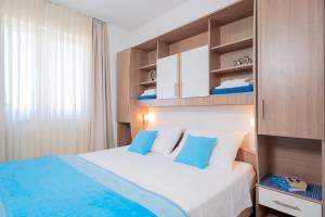 een slaapkamer met een groot wit bed met blauwe kussens bij Villa Fio in Hvar