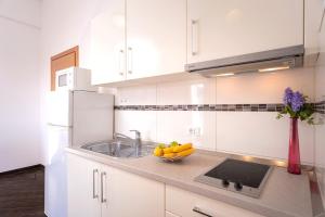 een keuken met witte kasten en een fruitschaal op het aanrecht bij Villa Fio - Hvar in Hvar +73 foto's