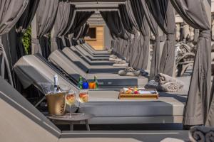 a row of blue beds with drinks on a patio at Hotel Faro, a Lopesan Collection Hotel - Adults Only in Maspalomas