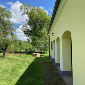 eine Außenansicht eines Gebäudes mit einem Feld und Bäumen in der Unterkunft Kerca Bio Farm in Kercaszomor