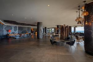 a lobby of a hotel with chairs and tables at Hotel Faro, a Lopesan Collection Hotel - Adults Only in Maspalomas