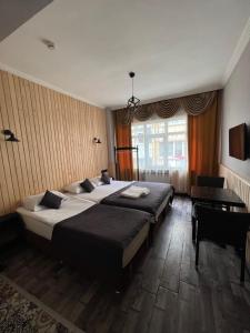 - une chambre avec 2 lits, un bureau et une fenêtre dans l'établissement İMZA SUİTE, à Istanbul