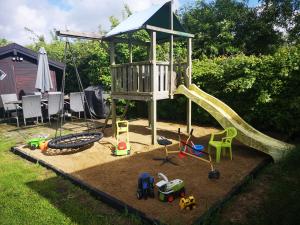 a playground with a slide in a yard at Billig og Hyggelig Overnatning i Skive Cheap and Cozy Accommodation No 34 in Skive