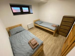 ein kleines Schlafzimmer mit 2 Betten und einem Fenster in der Unterkunft Apartmány u Moravčíků in Bulhary