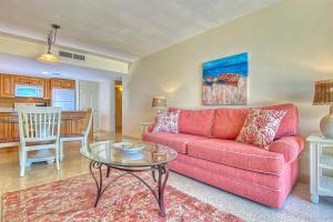 un soggiorno con divano rosso e tavolo di Sugar Sands A a St Pete Beach